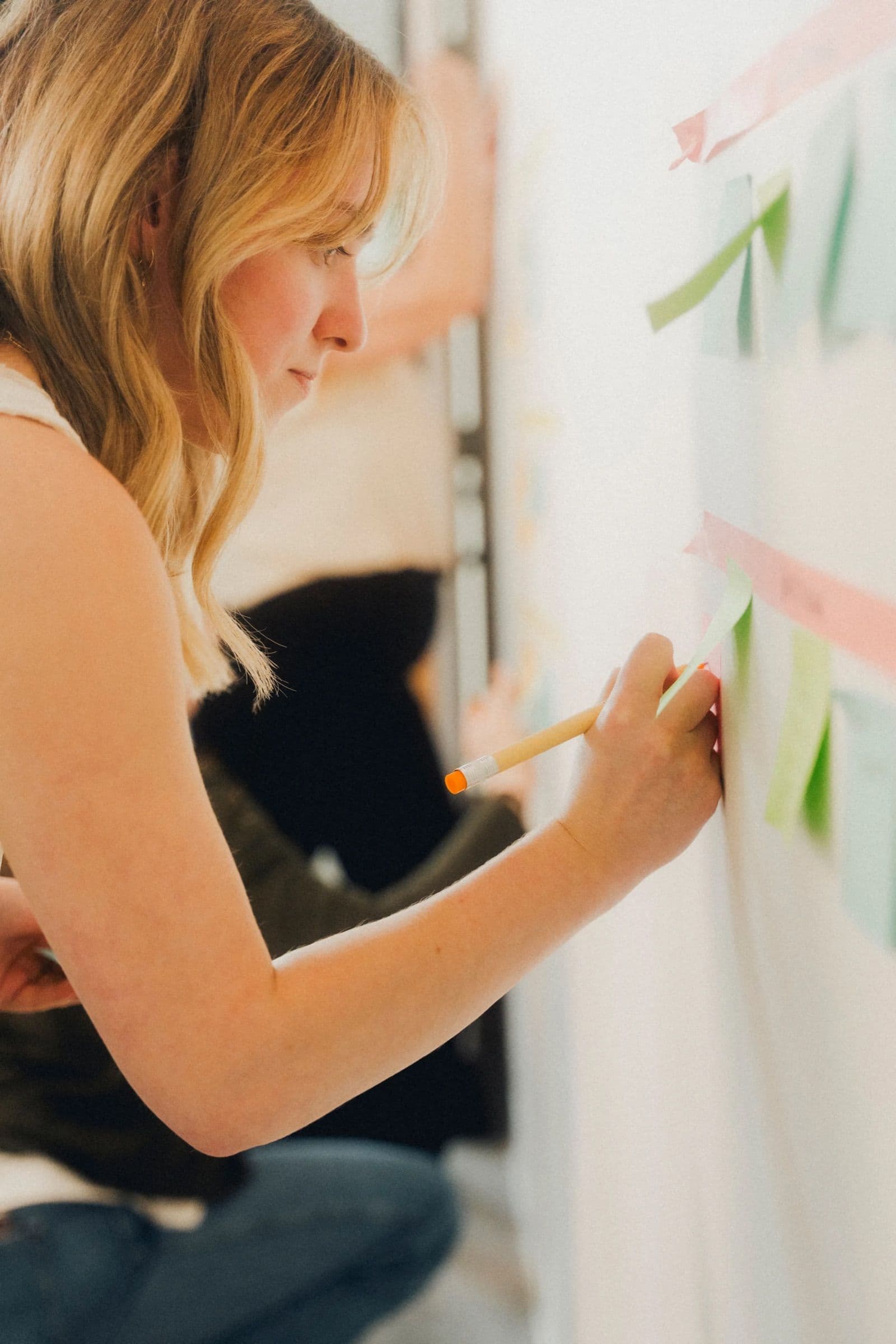 A designer pinning brand exploration boards to a wall