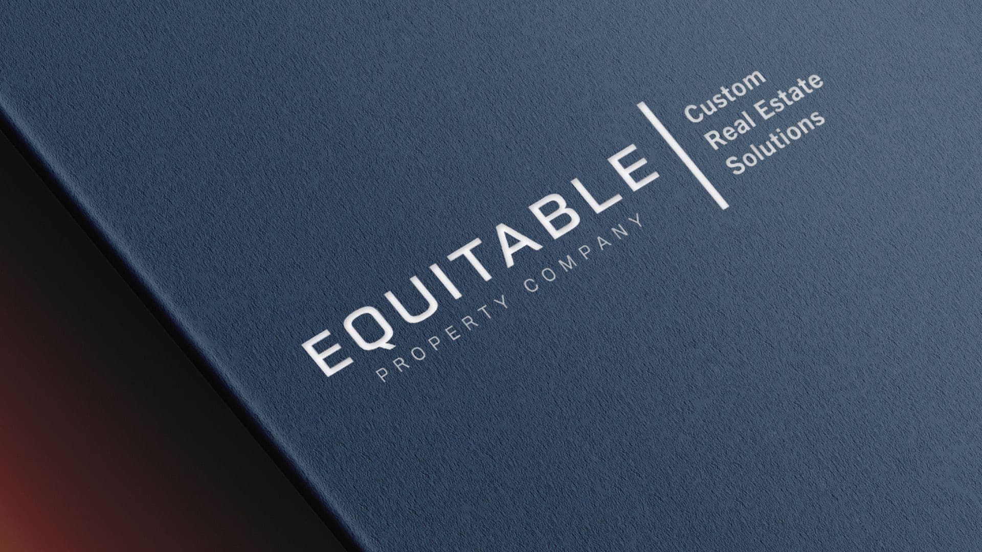 Close-up of the Equitable Property Company logo printed in white on a dark blue, textured background.
