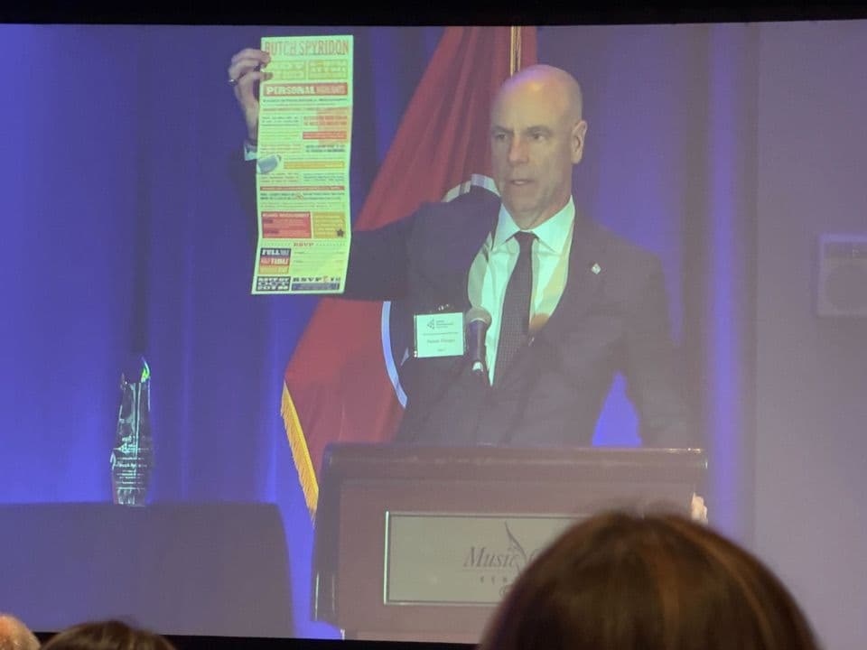 Damon Hininger holding up the unfolded invitation