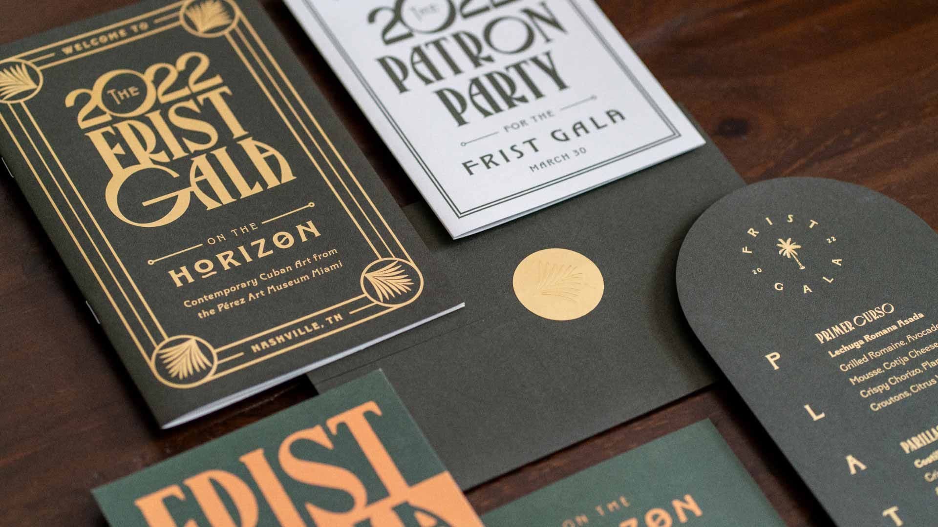 Photo of the 2022 First Gala invitation suite on a dark wood background