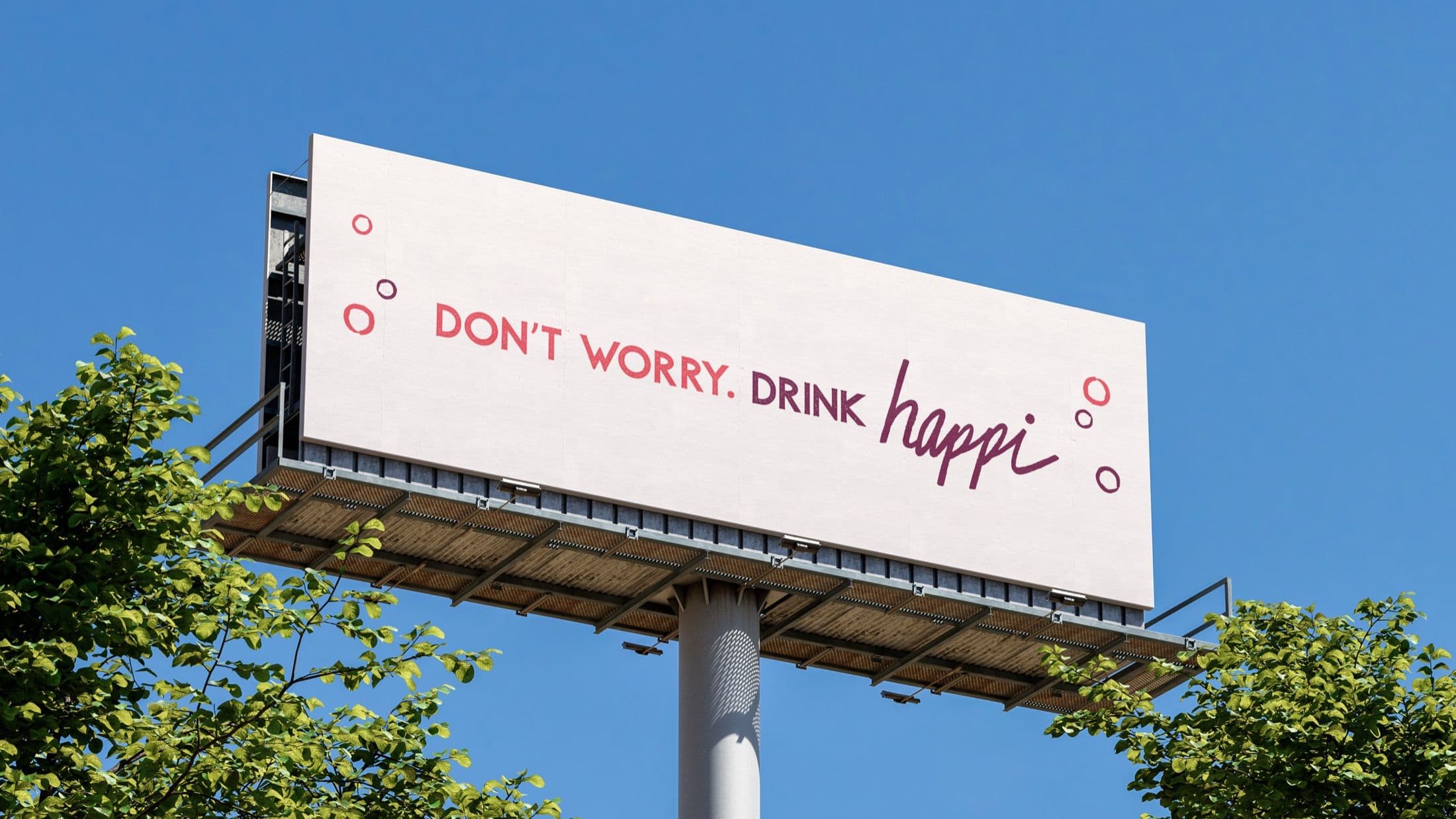 Large outdoor billboard advertisement for Happi seltzer on a sunny day, featuring the slogan 'DON'T WORRY. DRINK HAPPI.'