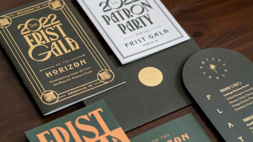 Photo of the 2022 First Gala invitation suite on a dark wood background